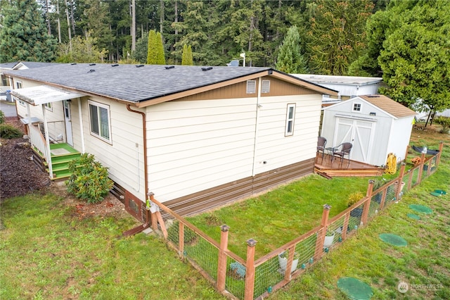 view of side of property featuring a storage unit and a lawn