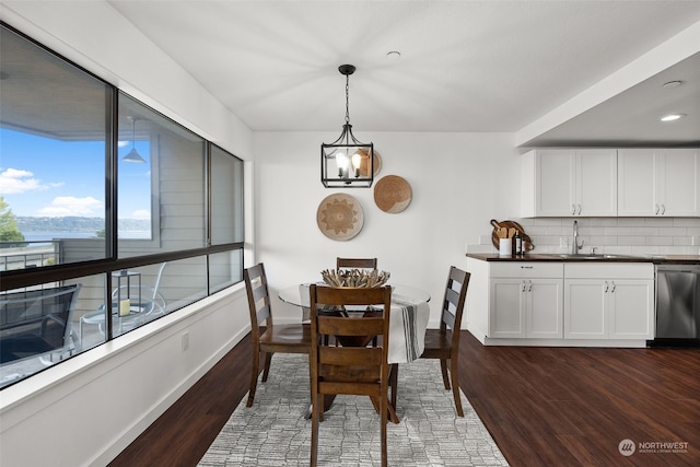dining area featuring dark wood-style flooring, baseboards, and a chandelier