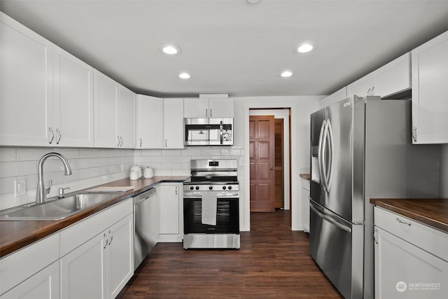 kitchen featuring appliances with stainless steel finishes, a sink, dark wood finished floors, recessed lighting, and tasteful backsplash