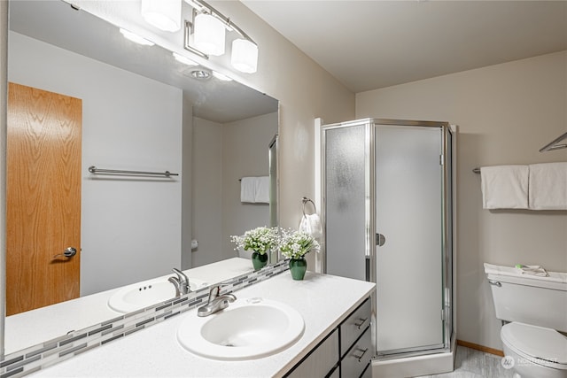 bathroom with vanity, a shower with shower door, and toilet