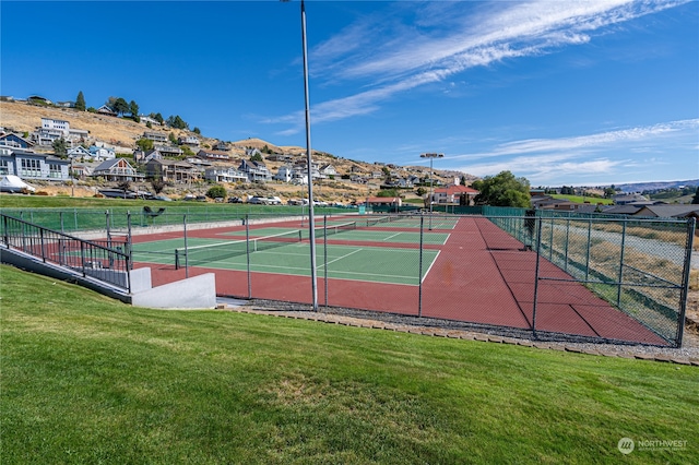 view of sport court with a lawn