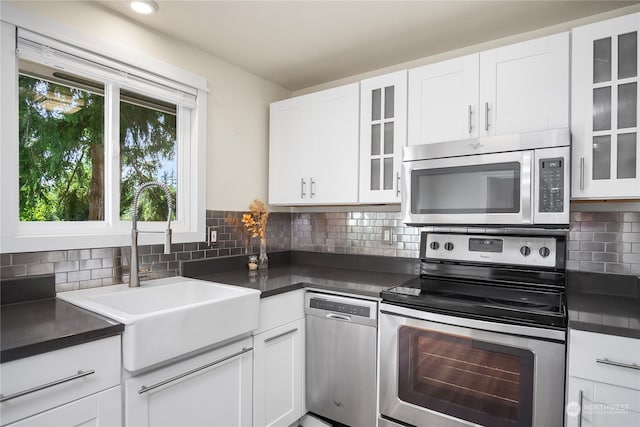 kitchen featuring stainless steel appliances, sink, tasteful backsplash, and white cabinetry