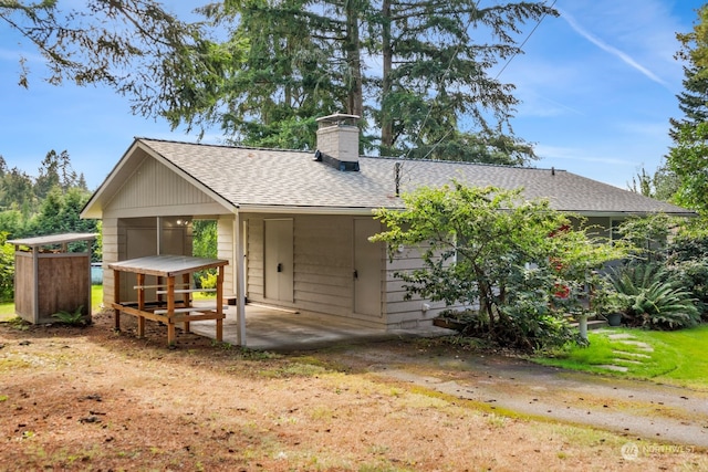 back of house featuring a lawn and a patio area