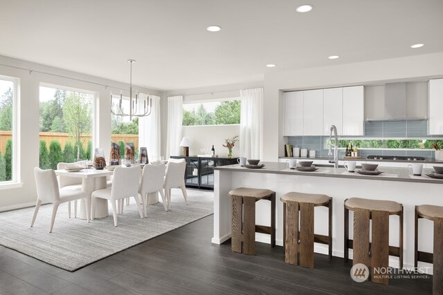 16331 25th St E, Lake Tapps, WA 98391 - kitchen featuring modern cabinets, dark wood-style flooring, wall chimney range hood, white cabinetry, and a breakfast bar area
