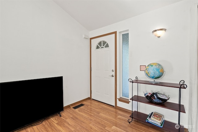 entryway with vaulted ceiling and light hardwood / wood-style flooring