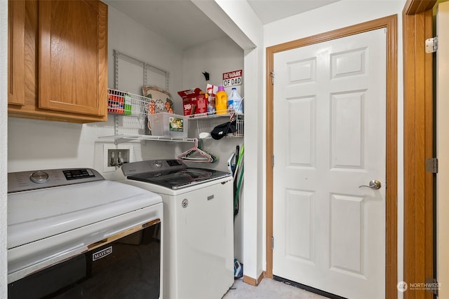 washroom featuring washer and dryer and cabinets