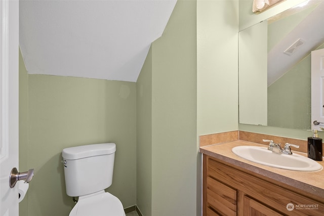 bathroom with vaulted ceiling, vanity, and toilet