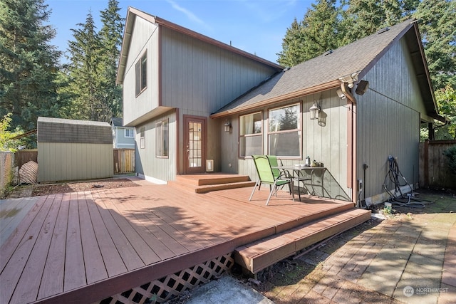 rear view of house with a deck and a storage shed