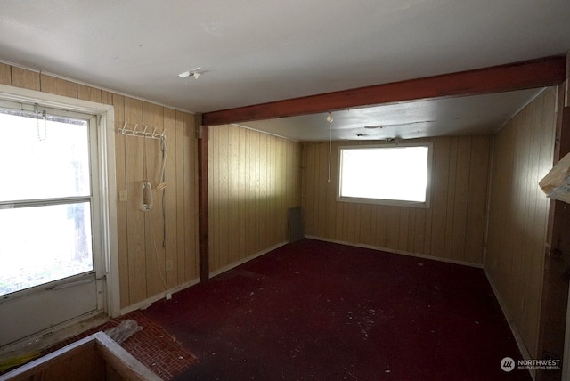 unfurnished room with wood walls