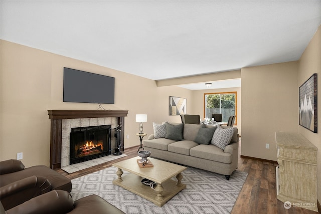 living room with a tile fireplace and hardwood / wood-style floors