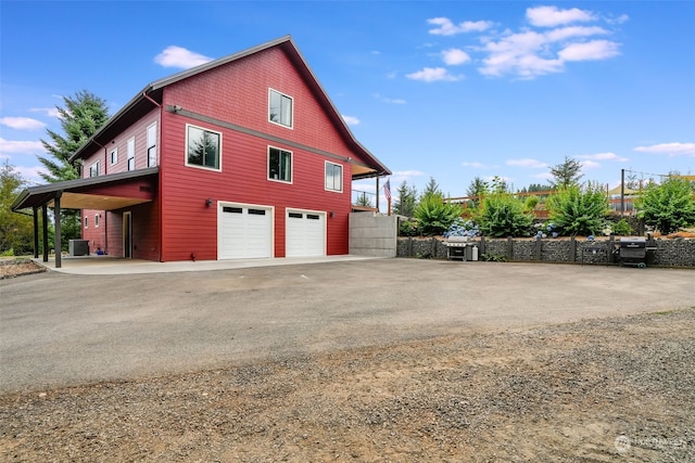 view of side of home featuring a garage and a carport