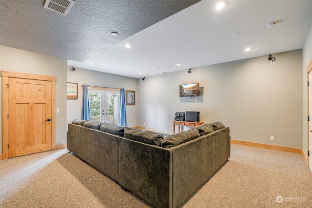 living room with a textured ceiling, light carpet, and french doors