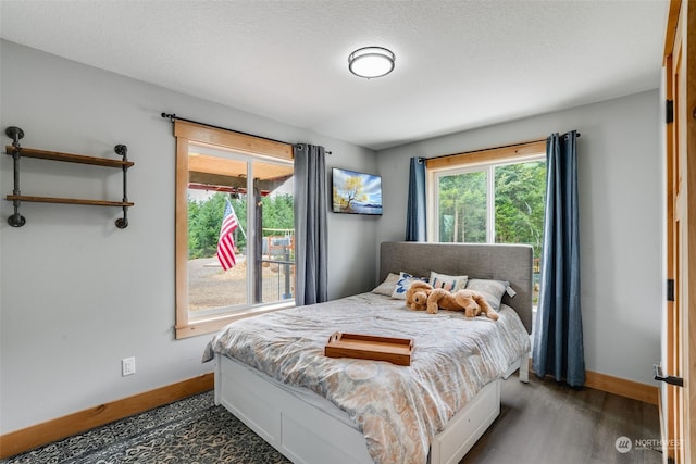 bedroom with dark wood-type flooring and a textured ceiling