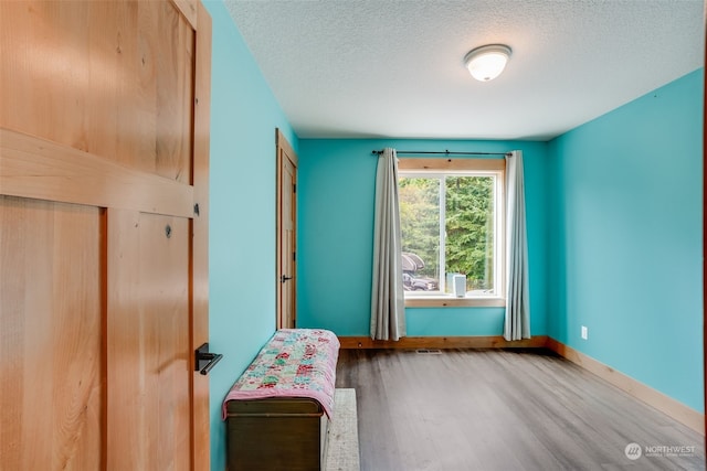 unfurnished bedroom featuring a textured ceiling and hardwood / wood-style flooring