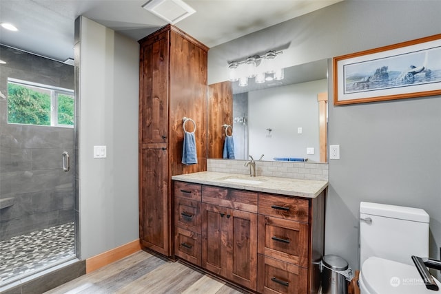 bathroom featuring vanity, an enclosed shower, decorative backsplash, hardwood / wood-style floors, and toilet