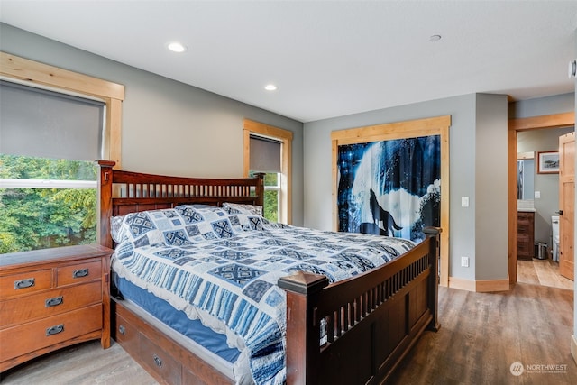 bedroom with hardwood / wood-style flooring and connected bathroom