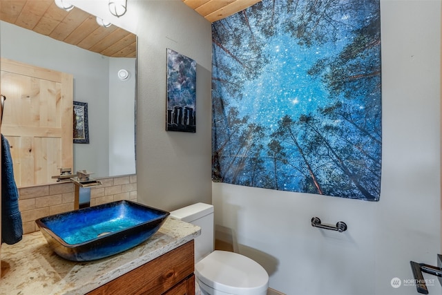 bathroom featuring wooden ceiling, vanity, toilet, and backsplash