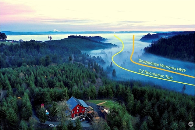 aerial view at dusk featuring a water view