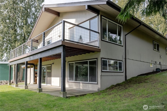 rear view of house featuring a patio and a lawn