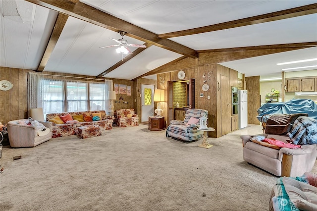 carpeted living area with vaulted ceiling with beams, a ceiling fan, and wood walls