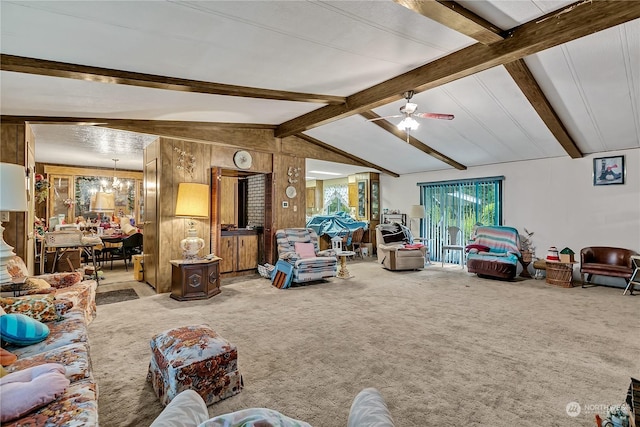carpeted living area featuring vaulted ceiling with beams, ceiling fan with notable chandelier, and wood walls