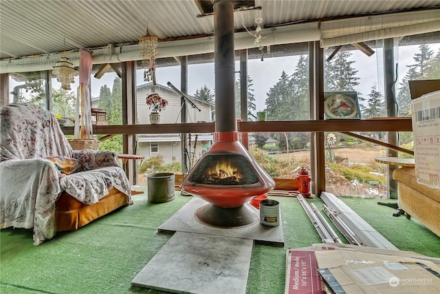 sunroom / solarium featuring plenty of natural light and a wood stove
