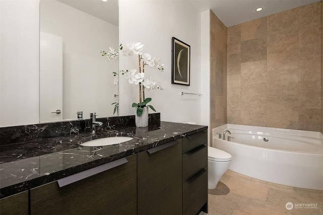 bathroom featuring vanity, a tub, and toilet