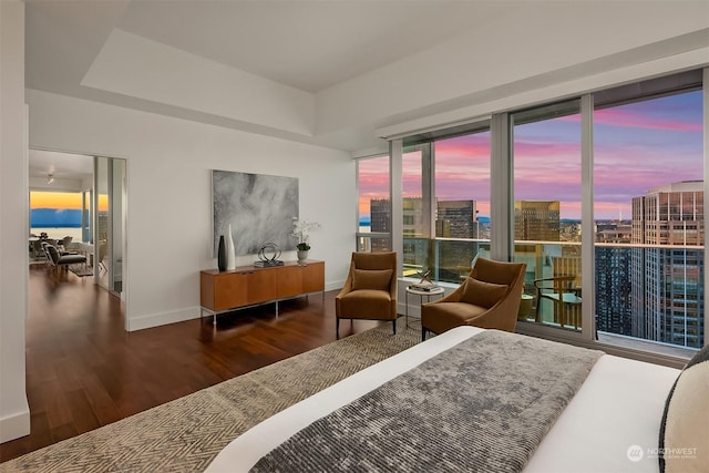 bedroom with wood-type flooring and a water view