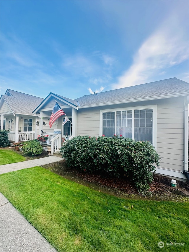 single story home with covered porch and a front yard