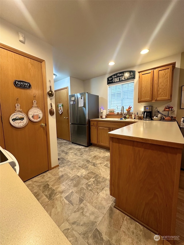 kitchen featuring stainless steel fridge and kitchen peninsula