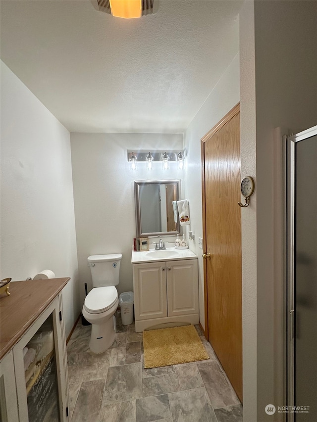 bathroom featuring vanity, toilet, and walk in shower