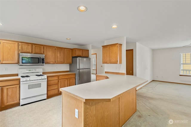 kitchen with light carpet, a center island, and appliances with stainless steel finishes