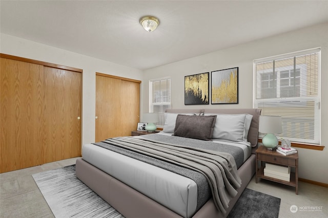 carpeted bedroom with multiple closets and multiple windows