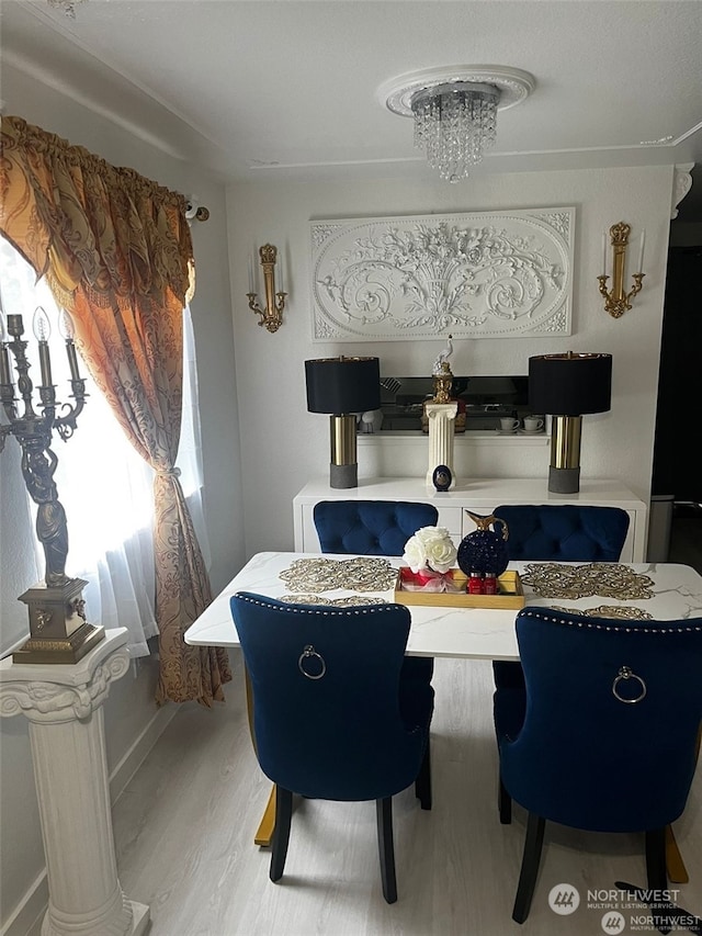 dining space featuring a notable chandelier and light wood-type flooring