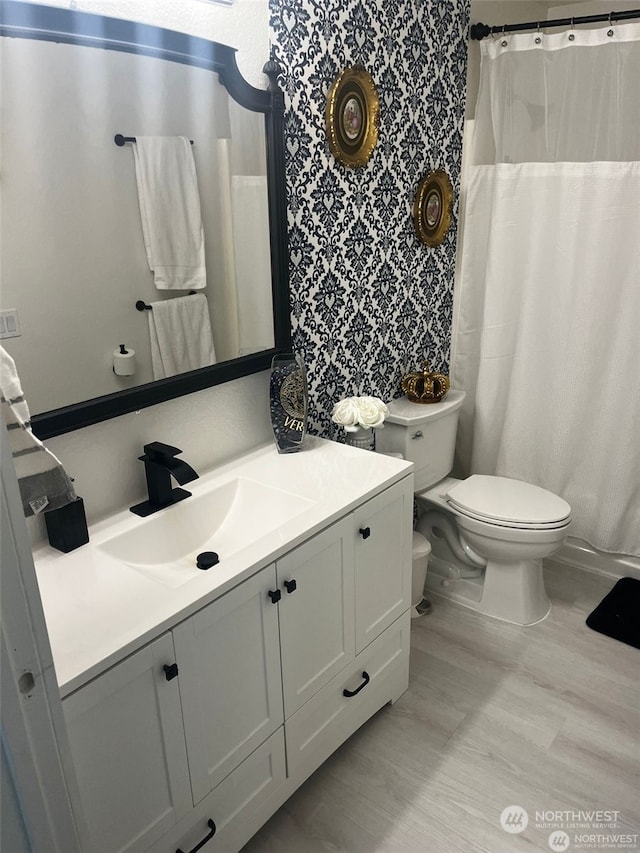 bathroom with curtained shower, vanity, and toilet