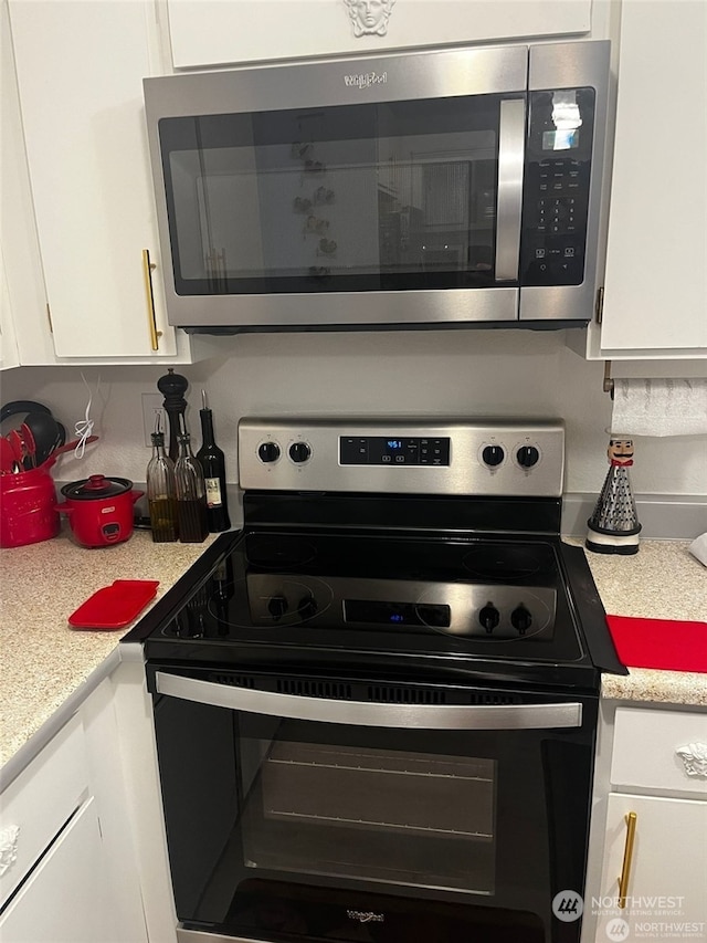 kitchen with stainless steel appliances and white cabinetry