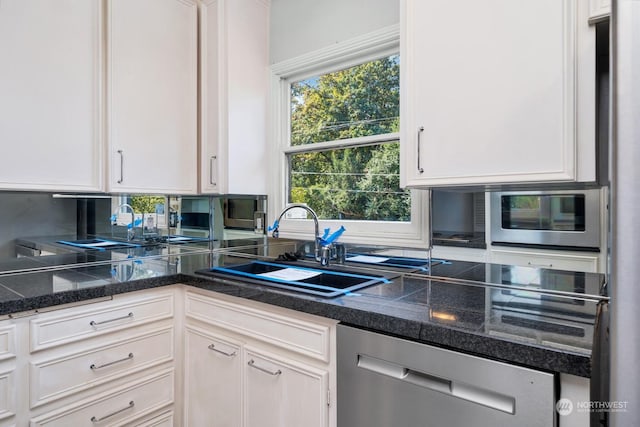 kitchen featuring dishwasher, white cabinetry, and sink