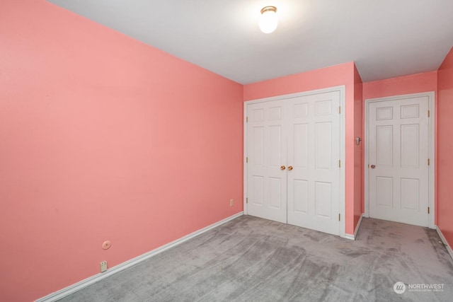 unfurnished bedroom with light carpet and a closet