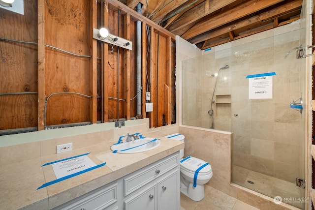 bathroom featuring tile patterned flooring, a shower with door, vanity, and toilet