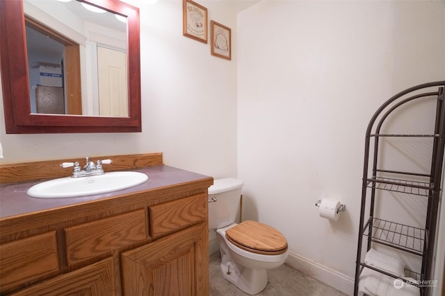 bathroom with vanity, tile patterned flooring, and toilet