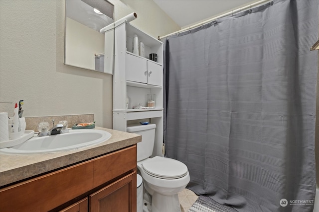 bathroom featuring tile patterned flooring, walk in shower, vanity, and toilet