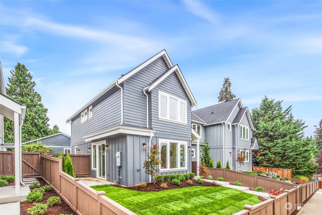 rear view of property featuring a lawn