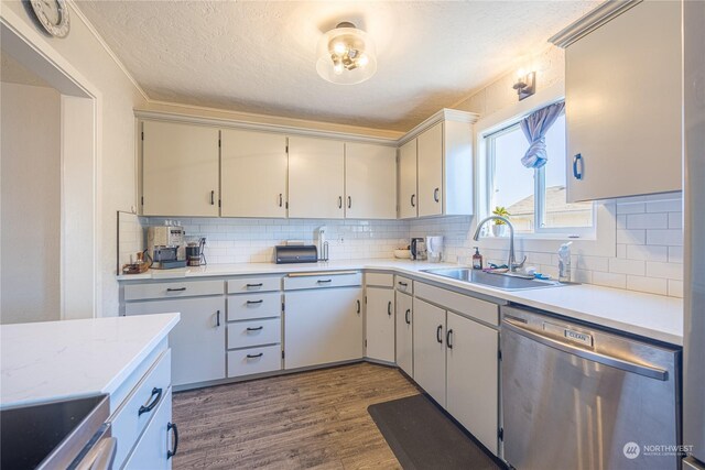 kitchen with backsplash, stainless steel appliances, a textured ceiling, dark hardwood / wood-style floors, and sink