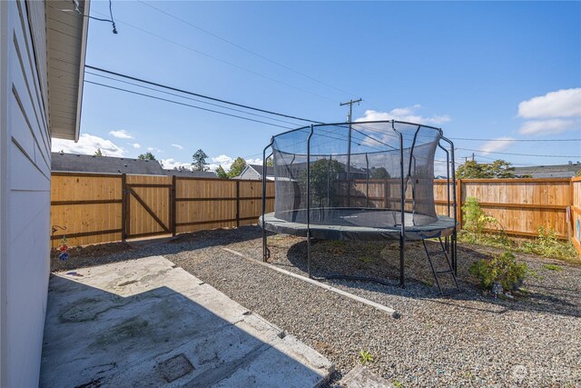 view of yard featuring a trampoline and a patio area