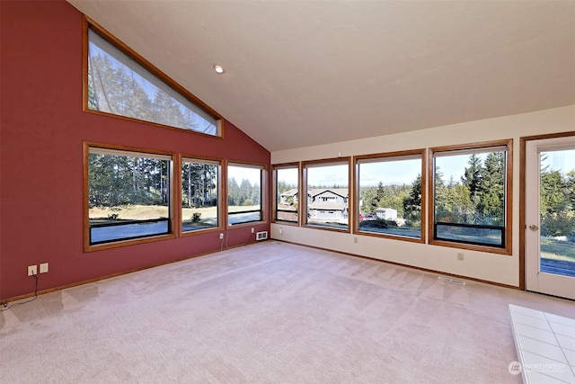 interior space with light carpet, high vaulted ceiling, and a wealth of natural light