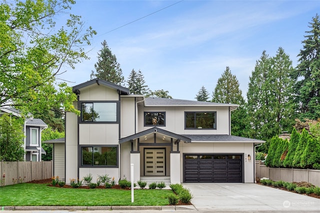 view of front facade featuring an attached garage, a shingled roof, fence, driveway, and a front yard