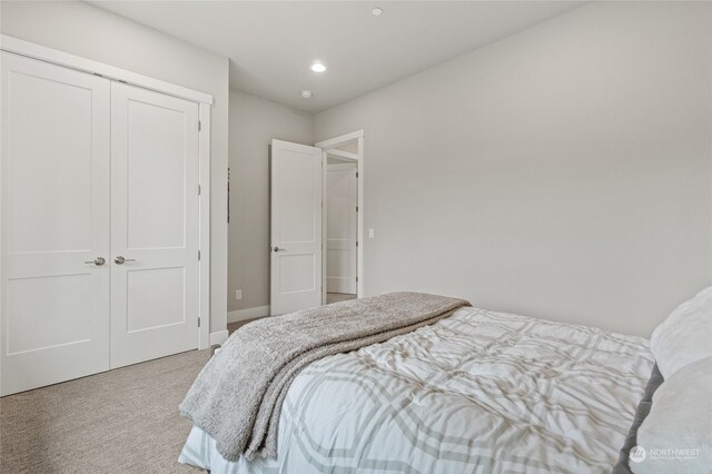 bedroom featuring light colored carpet and a closet