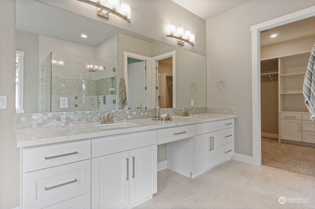 bathroom featuring tile patterned flooring, walk in shower, and vanity