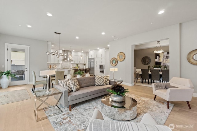 living room with recessed lighting, light wood-style flooring, and baseboards