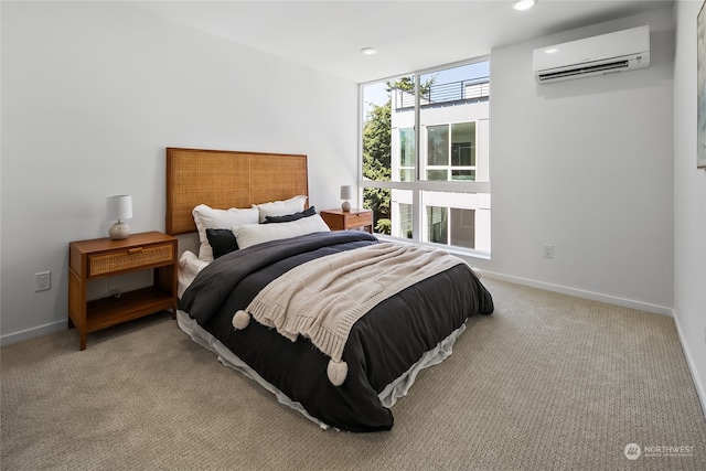 bedroom with a wall mounted AC and light colored carpet